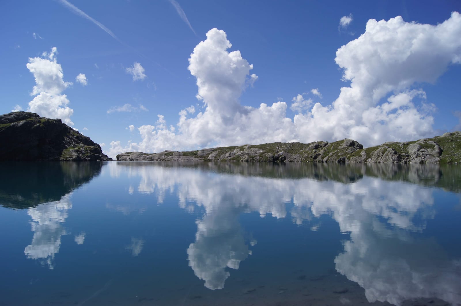 Bergsee mit Wolkenspiegelung im Querformat